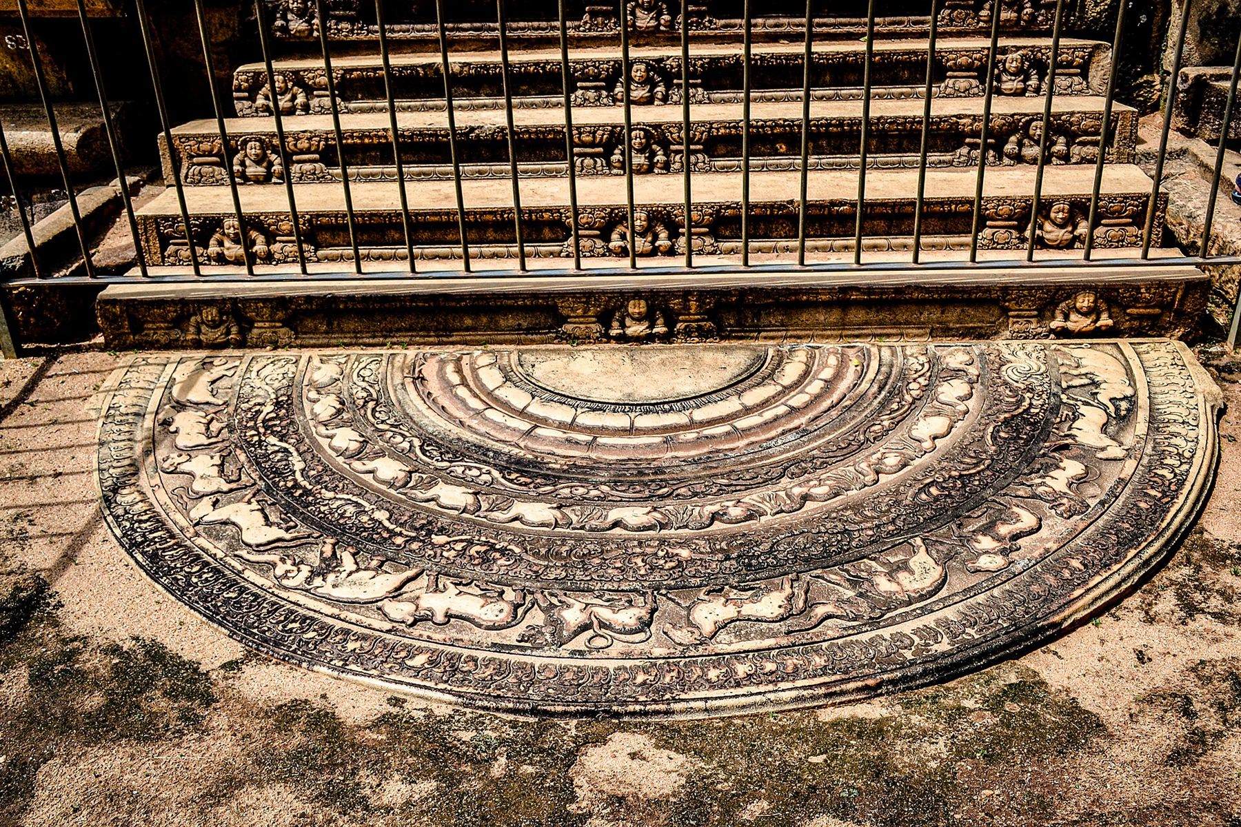 A sandakaḍa pahana moonstone carved in concentric bands of flame, animals and lotus.