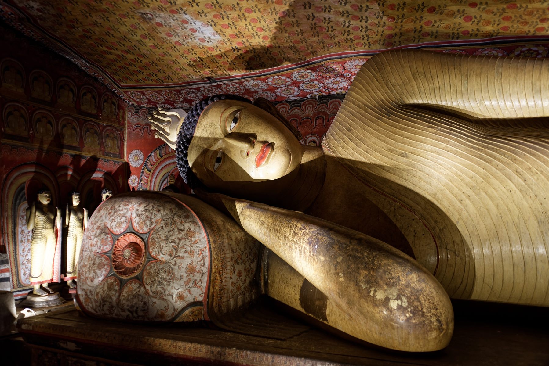 A reclining Buddha carved from the living rock inside the cave temple at Dambulla.